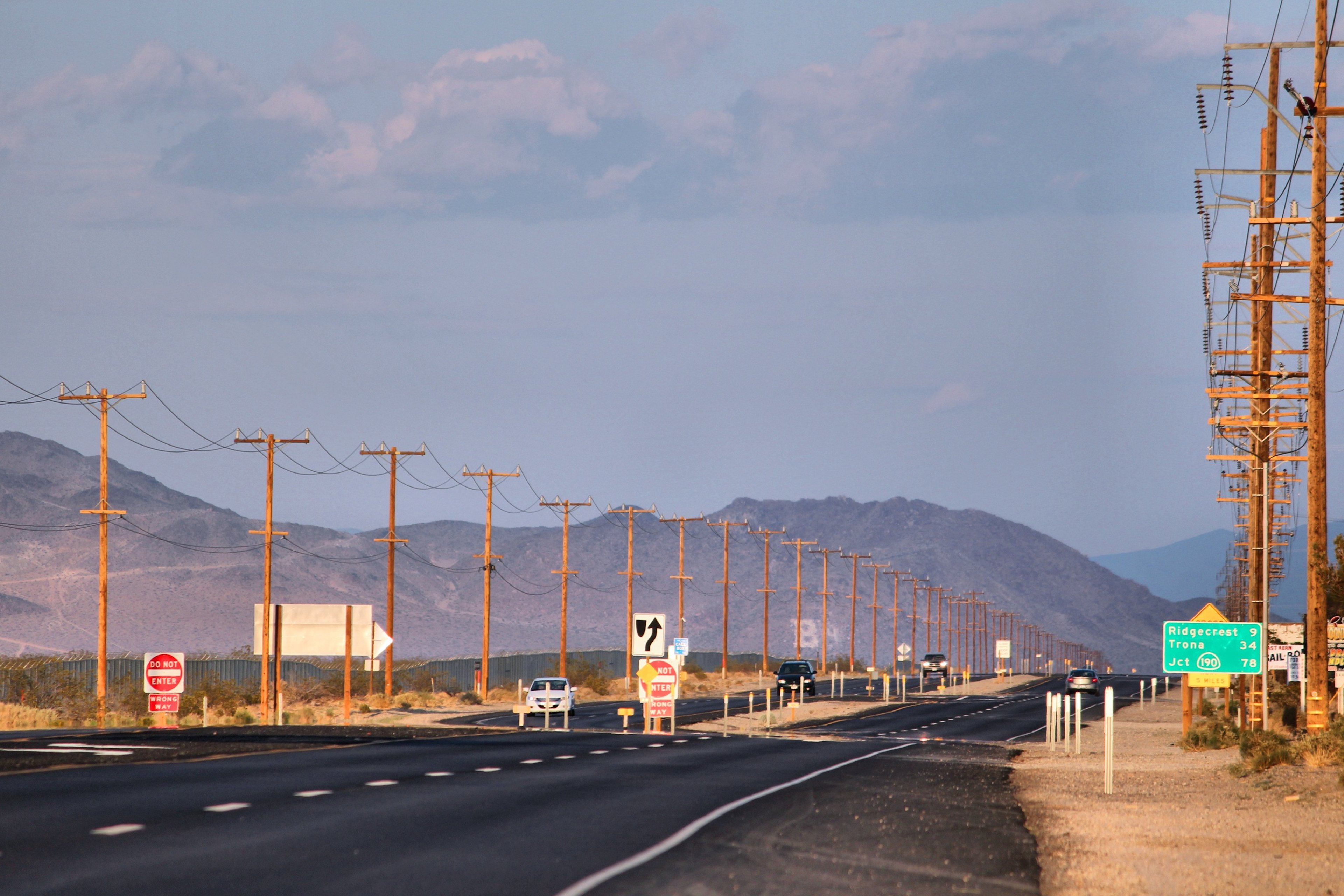 California Route 178 in Inyokern. Road lined with wooden electric poles. Electric grid in America, wooden utility poles.